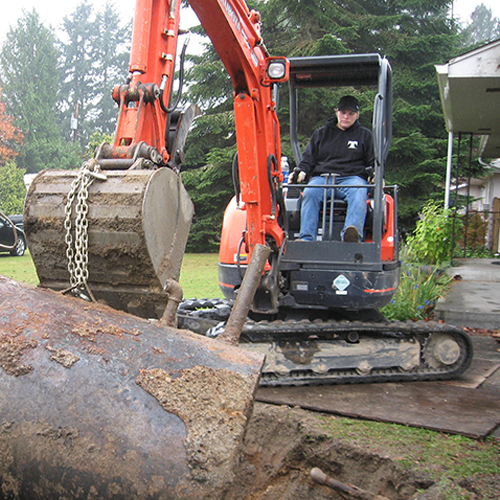 Ashley Langseth (Ruhl) operating a mini excavator while removing an outdated and polluted oil tank